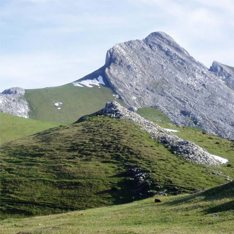 Aizkorritxo tontorra izen bereko trikuharritik ikusita; atzean Arbelaitz eta Iraule